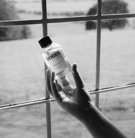 Arborealist Bath Oil held in front of window