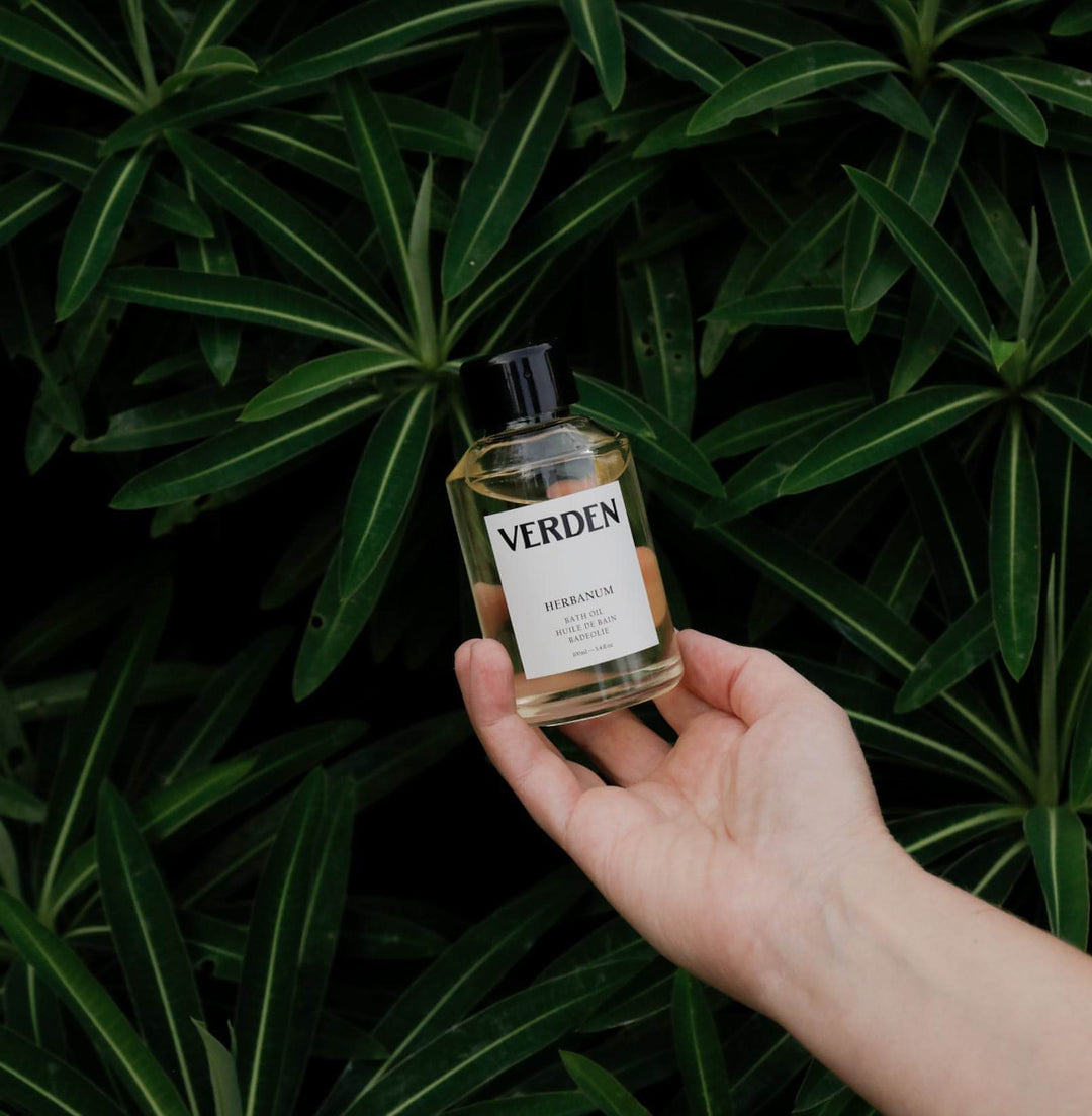 Herbanum Bath Oil held by leaves